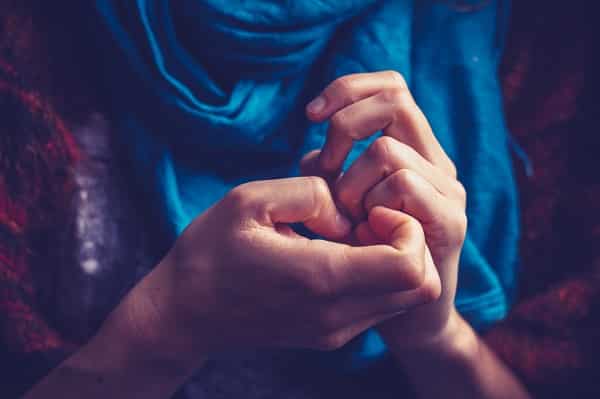 Close up on a young woman's hands as she is picking her nails out of anxiety