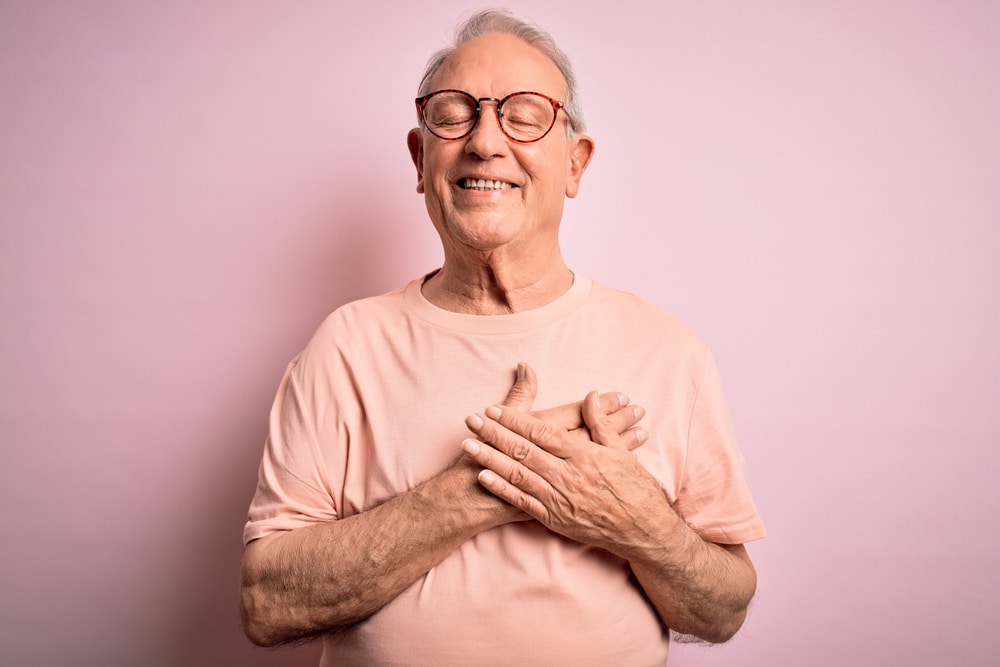 Grey,Haired,Senior,Man,Wearing,Glasses,Standing,Over,Pink,Isolated
